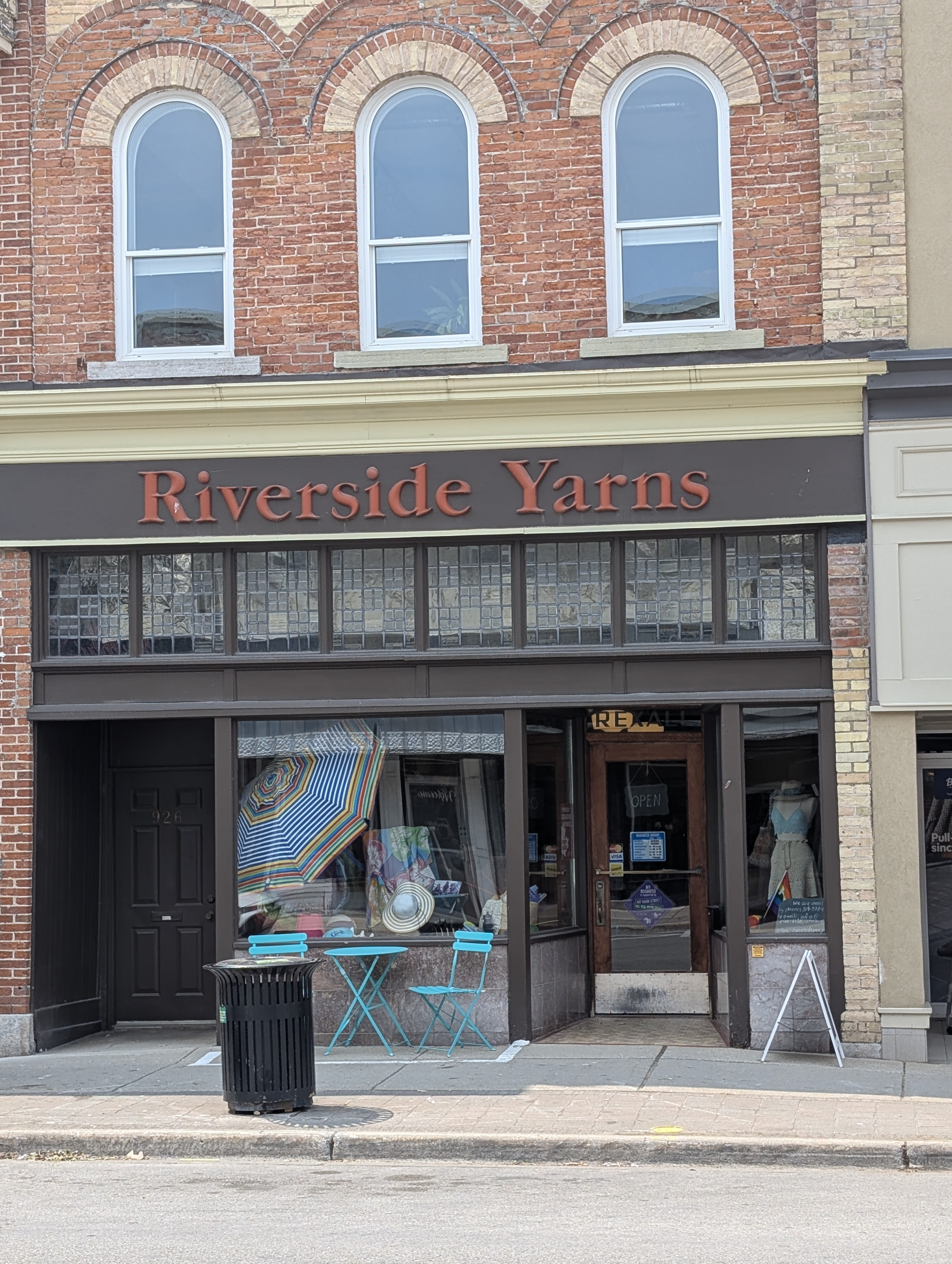 Storefront of Riverside Yarns with a brick building facade.